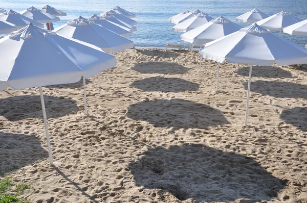 Bílé slunečníky na pláži. — Stock fotografie