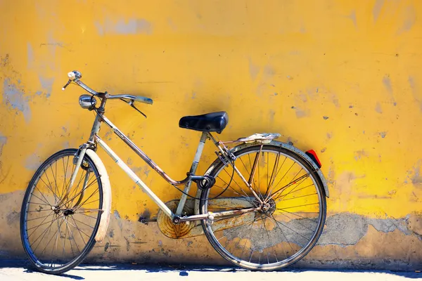 Vieja bicicleta contra la pared en casa — Foto de Stock