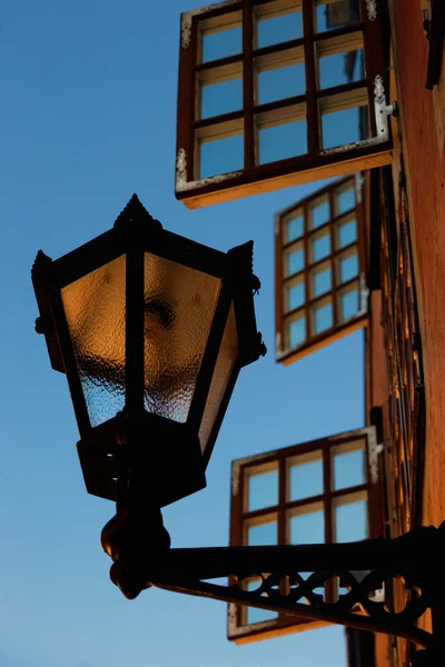 Lantern on the wall in the background of open windows — Stock Photo, Image
