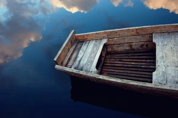 Drewniane łódź w obłokach odzwierciedlona w wodzie — Zdjęcie stockowe