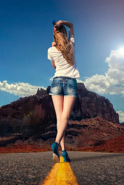 Dziewczyna spaceruje po drodze na pustyni — Zdjęcie stockowe