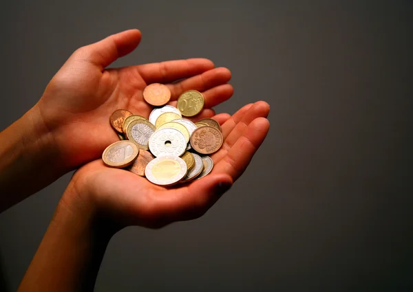 Peníze mince v dítěti ruce — Stock fotografie