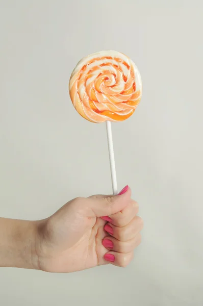 stock image Lollipop in his hand on a white background