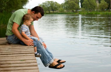 Father and son at the river clipart