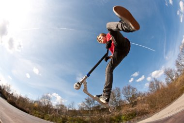 Boy jumping with a scooter clipart