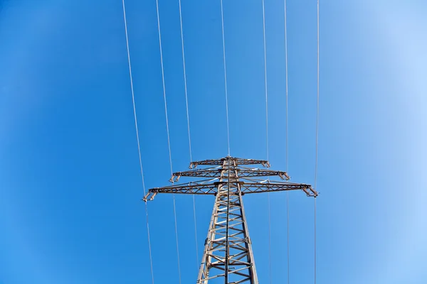 Energii elektrycznej wysokiego napięcia wieża z błękitnego nieba — Zdjęcie stockowe