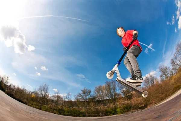 Rapaz a saltar com uma scooter — Fotografia de Stock