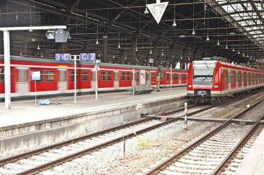 Iron classicistic train station from inside with red trains clipart