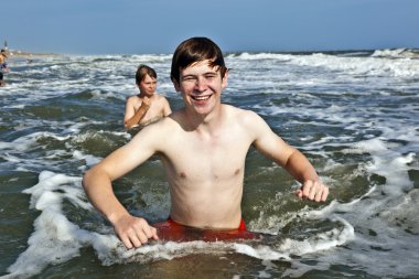 Boy enjoying the beautiful ocean and beach clipart