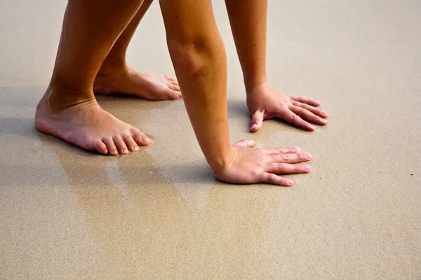 Ноги и руки на прекрасном песчаном пляже — стоковое фото