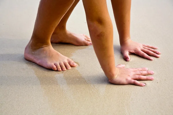 Nohy a ruce na krásné písečné pláži — Stock fotografie