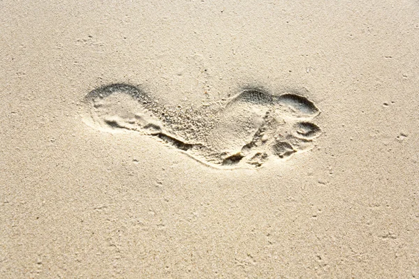 Mänskliga vuxen fotavtryck i fina sanden på stranden — Stockfoto