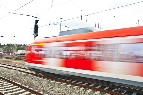 Train rouge en mouvement dans la gare — Photo