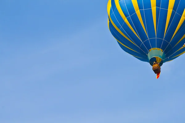 Hete luchtballon in bewolkte hemel — Stockfoto