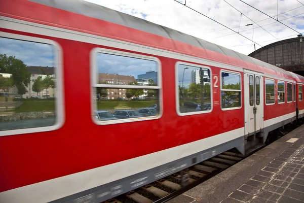 Красный поезд покидает станцию — стоковое фото