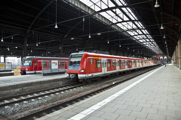 Rode trein verlaat het station — Stockfoto