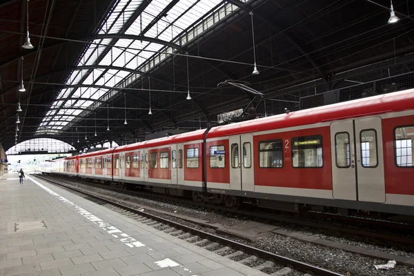 Comboio vermelho sai da estação — Fotografia de Stock