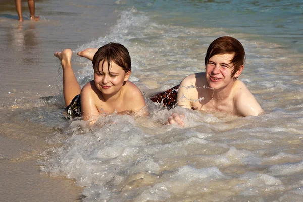Bratři jsou ležící na pláži a užívat si slunce a wa — Stock fotografie