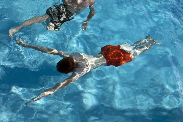 Irmãos se divertem na piscina ao ar livre — Fotografia de Stock