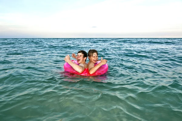 Frères dans un anneau de natation amusez-vous dans l'océan — Photo