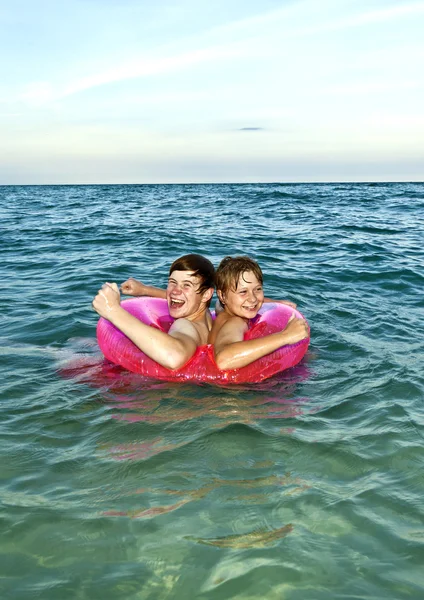 Bracia w pierścień pływać bawić się w Oceanie — Zdjęcie stockowe