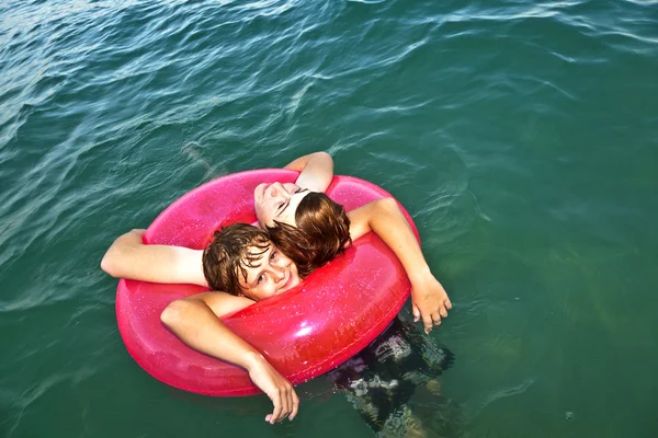 Irmãos em um ringue de natação se divertir no oceano — Fotografia de Stock