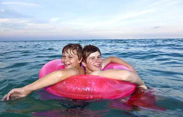 Frères dans un anneau de natation amusez-vous dans l'océan — Photo