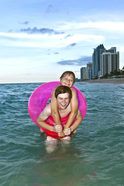 Bracia w pierścień pływać bawić się w Oceanie — Zdjęcie stockowe