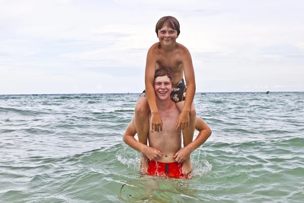 Fratelli che si divertono insieme nel bellissimo oceano — Foto Stock
