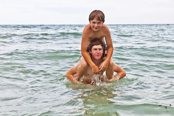 美しい海で一緒に楽しんで兄弟 — ストック写真