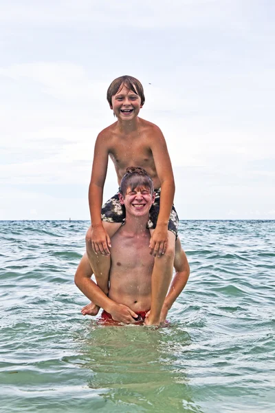 Bröderna ha roligt tillsammans i det vackra havet — Stockfoto