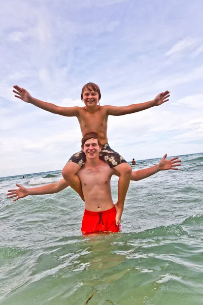 Irmãos se divertindo juntos no belo oceano — Fotografia de Stock