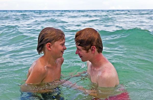 Irmãos se divertindo juntos no belo oceano — Fotografia de Stock