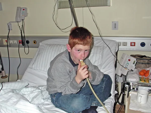 Young boy in hospital using a machine — Stock Photo, Image