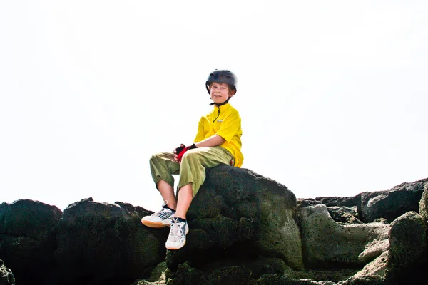 Orgoglioso ragazzo si rilassa su una pietra in mountainbike vestito — Foto Stock