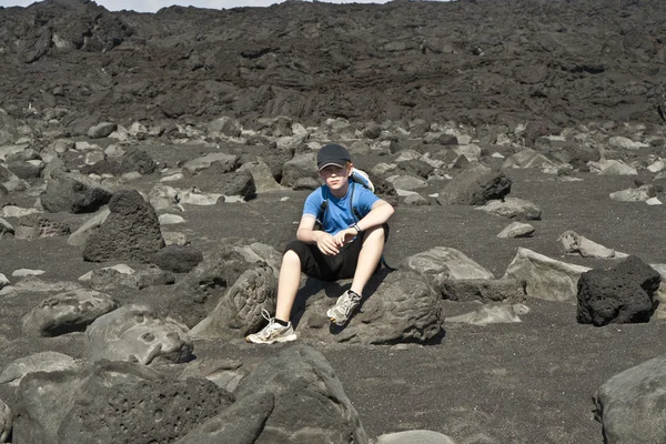 Chlapec na pěší stezku přes vulkanické oblasti v lanzarote — Stock fotografie