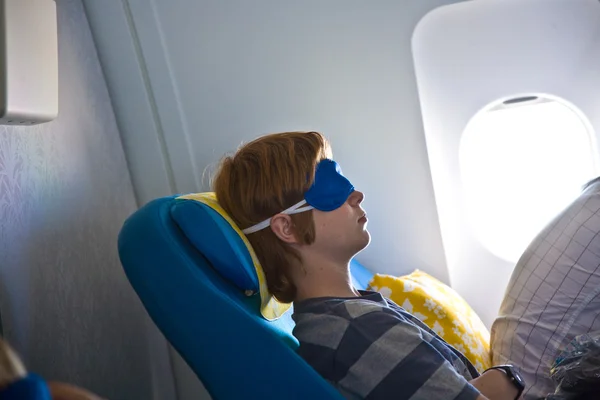 Молодой пассажир спит в самолете — стоковое фото