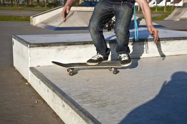 Хлопчик з скейтбордом збирається в повітрі — стокове фото