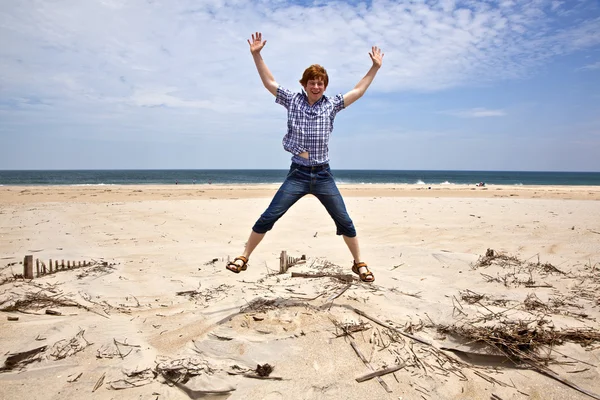 Boy enjoys the beautiful beach and jumps — Stock Photo, Image