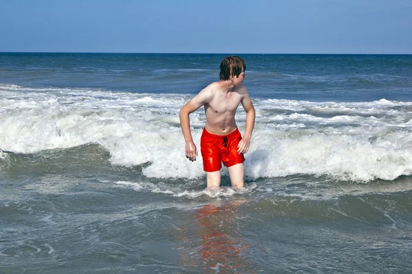 Jeune garçon est corps surf dans les vagues — Photo