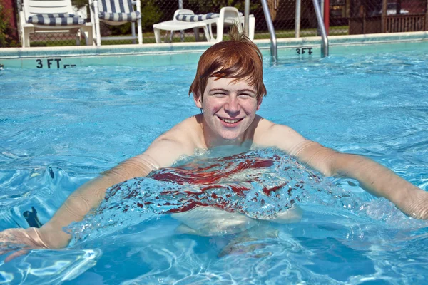 Menino se diverte na piscina ao ar livre — Fotografia de Stock