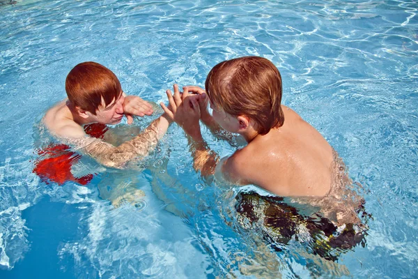 Bracia bawią się w odkrytym basenie — Zdjęcie stockowe