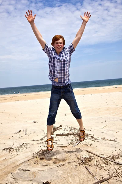 Мальчик наслаждается прекрасным пляжем и прыгает — стоковое фото