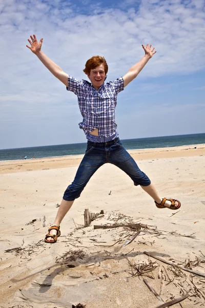 Ragazzo gode la bella spiaggia e salta — Foto Stock