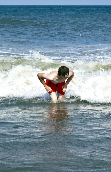 Junge surft mit dem Körper in den Wellen — Stockfoto