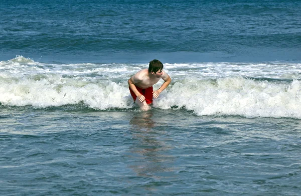 Fiatal fiú a test-szörfözés a beaufiful hullámok — Stock Fotó
