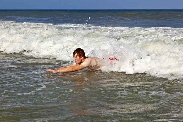 Joven chico es el cuerpo surfeando en las hermosas olas —  Fotos de Stock