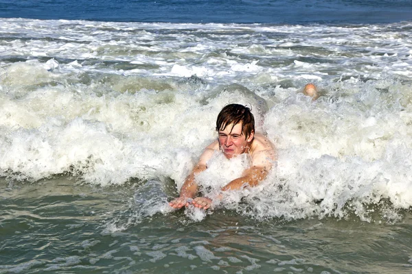 Ung pojke är body surfing i beaufiful vågor — Stockfoto