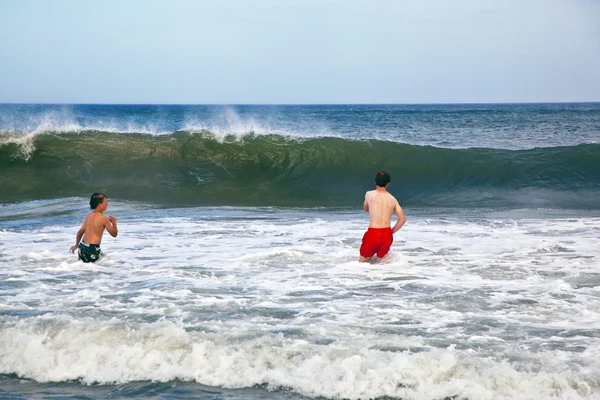 Хлопчики розважаються в хвилях океану — стокове фото