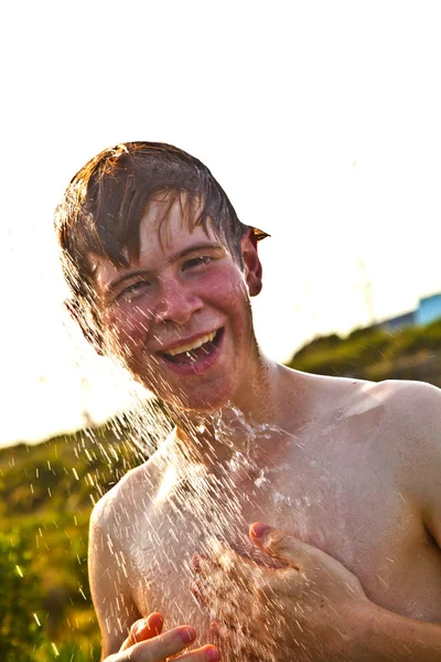 Хлопчик приймає душ на пляжі — стокове фото